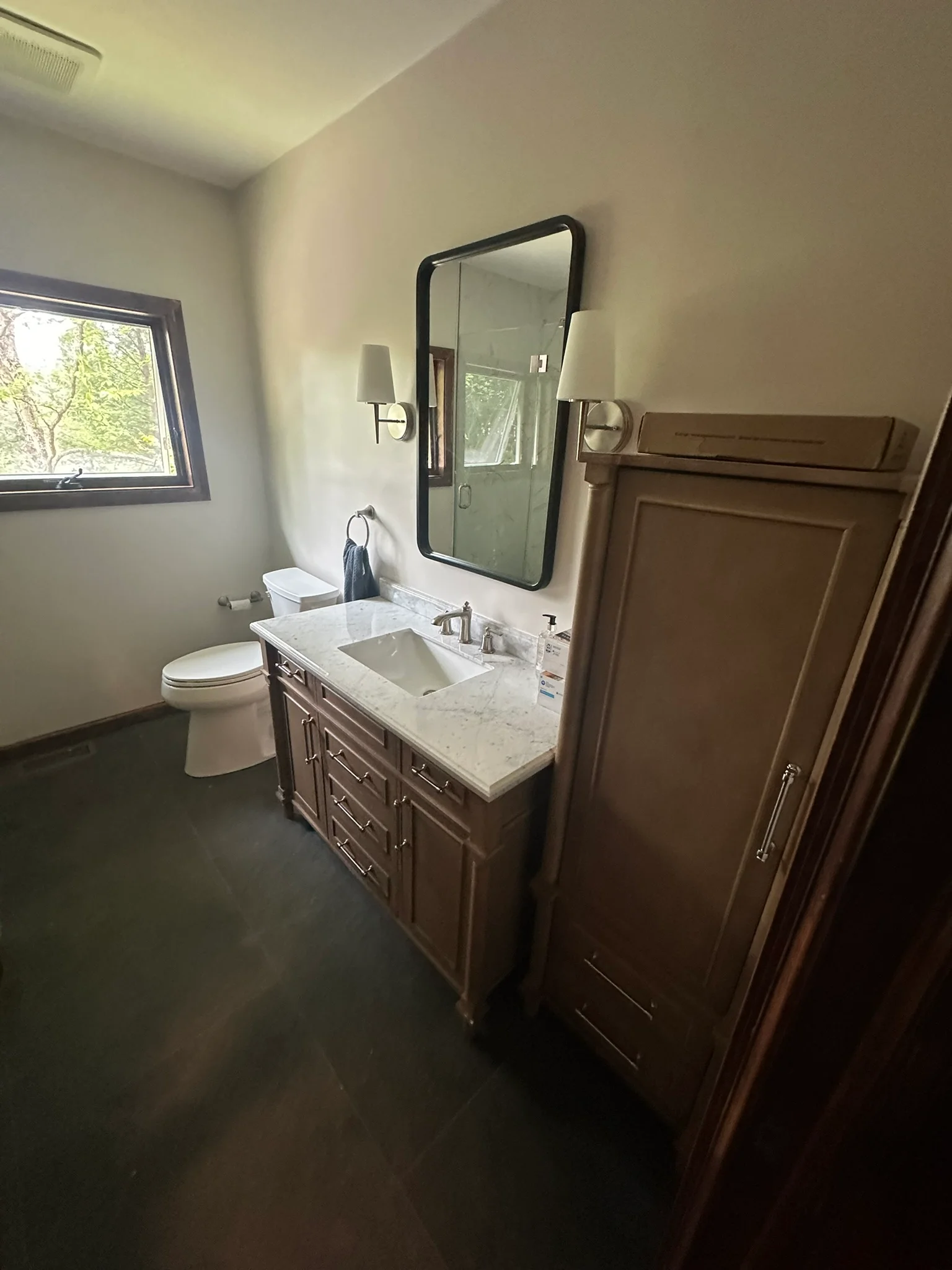 Modern bathroom with dark wood vanity, marble countertop, and black framed mirror — Drywall Installation by Innovative Build Solutions.